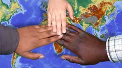 image about world charity. Multi-cultrual hands over a map of the world.